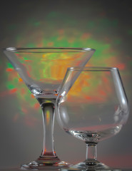 Martini Glass together with Cognac Glass with flashing bright green and yellow lights on background