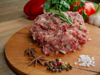 Minced beef with onions and black pepper on a wooden board 