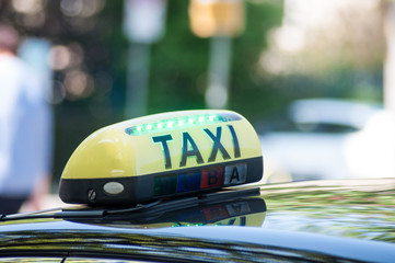 closeup of taxi sign on car parked in the street