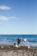 Child plays with buckets and shovels on the beach