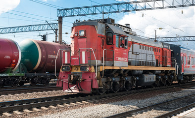 Electric locomotive with wagons at the city station. Front view