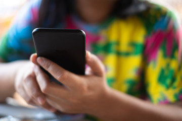 closeup woman's hand holding and using smartphone with blur background. subject is blur.