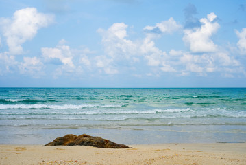 Landscape or seascape view of beach facing out to the ocean in Samet Island, Thailand. Seen in the morning. Blue sky with some cloud and rock in foreground. Vacation and holiday on beach concept.
