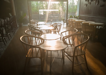 Restaurant interior with a tables and chairs near the door in the morning sunlight