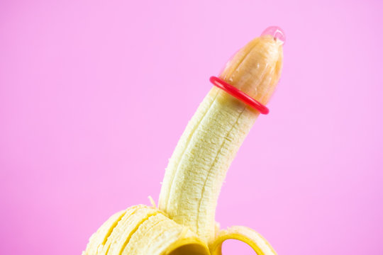closeup condom on banana with pink background (World AIDS Day concept), soft focus.