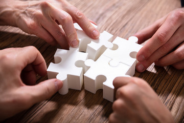 Businesspeople Solving Jigsaw Puzzle Together