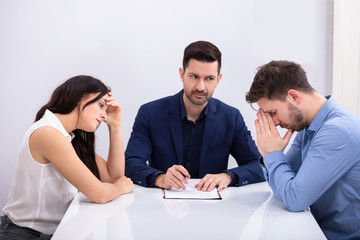 Fototapeta premium Depressed Couple Sitting In Front Of Judge