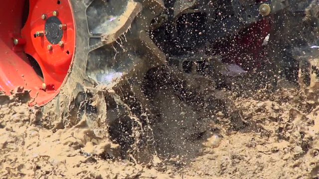 view footage drive tractor rides on an impassable mud, performance test, slow motion shot
