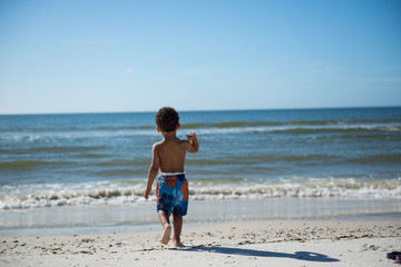 Fototapeta na wymiar little boy playing on the beach