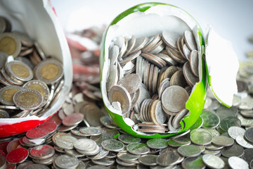 Piggy bank broken and money coins scattered across the floor. Financial problem concept.