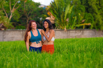 latin girl and her attractive Caucasian girlfriend both women enjoying Summer holidays having fun together on rice field smiling happy relaxed in diversity friendship and love