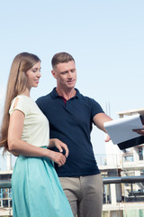 portrait of nice young couple studying contract on construction area background