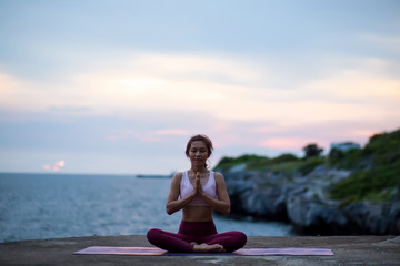 Fototapeta na wymiar happy healthy women practicing yoga. sitting in lotus pose meditation outdoors concentrating breathing asana yoga.Easy Pose. .beautiful landscape view sky on evening sunset nature evening outdoor.