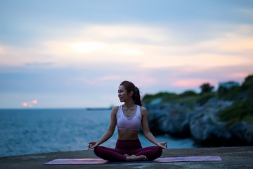 Fototapeta na wymiar Healthy Feeling women practicing yoga. sitting in lotus pose meditation outdoors concentrating breathing asana yoga. .beautiful landscape view sky on evening sunset nature evening outdoor.