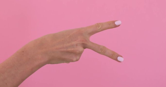 Woman hand show rock paper scissors game pink background