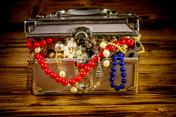Jewelry box full of jewelry and accessories on wooden background