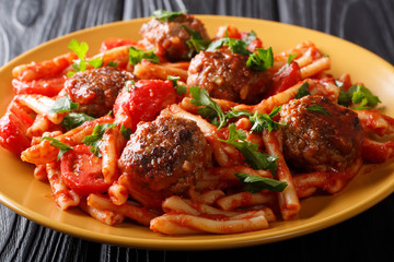 Italian pasta Casarecce with meat balls in tomato sauce closeup on a plate. horizontal