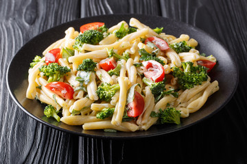 portion of Casarecce pasta with vegetables, herbs, seasoned with creamy cheese sauce close-up on a plate. Horizontal