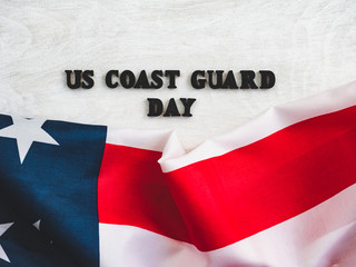 Fototapeta na wymiar Beautiful card for US Coast Guard Day. Wooden letters with a congratulatory inscription on a white background. Close-up, top view. Congratulations for loved ones, relatives, friends and colleagues