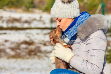 Woman playing with dog during winter