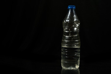 Plastic water bottle isolated on black background