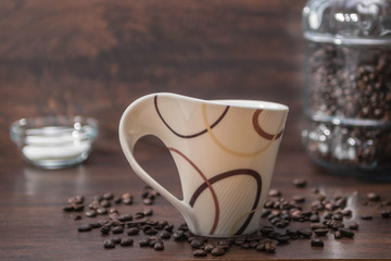 Obraz na płótnie Canvas Coffe Cup with Spreading Coffee Beans and Coffee Container