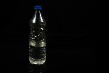Plastic water bottle isolated on black background