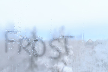 Inscription frost on frozen cold of the winter window