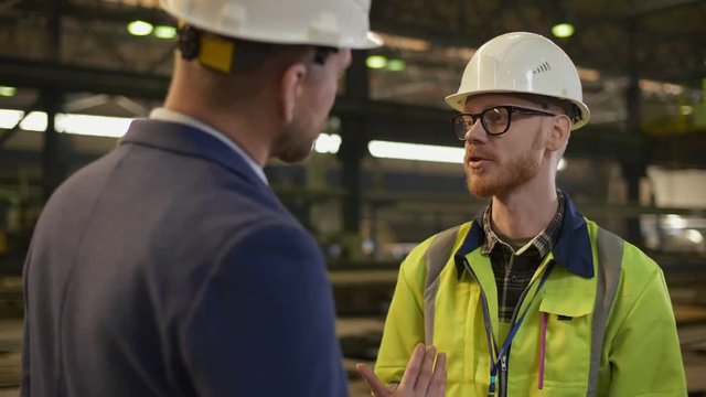 Industrial factory manager talking to engineer