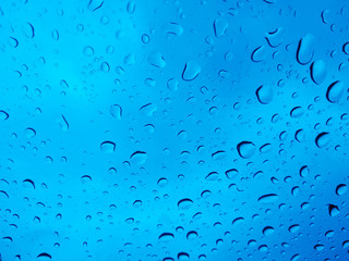 Blue abstract background from water drops on glass