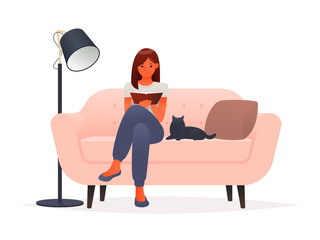Young woman is reading a book while sitting on a sofa on a white background