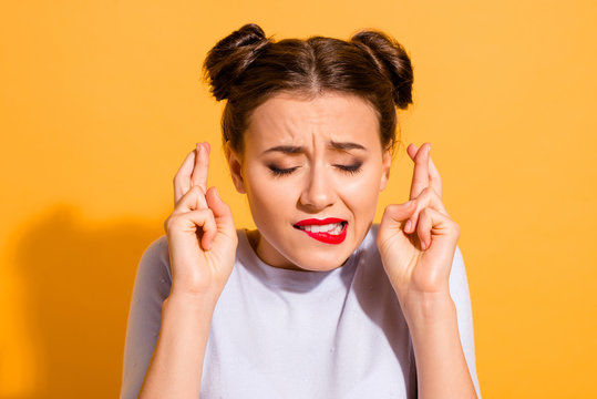 Close-up portrait of her she nice-looking attractive lovely nervous glamorous girl crossed fingers hope biting lip praying isolated over bright vivid shine yellow background