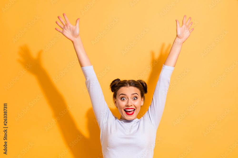 Wall mural Portrait of her she nice-looking attractive lovely winsome sweet adorable crazy cheerful cheery teen girl having fun rejoicing raising hands up isolated on bright vivid shine yellow background