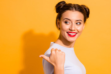 Close up portrait of carefree funky isolated childish lady pointing with her thumb dressed in white sweater over yellow background