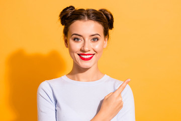 Close up photo of charming self-assured attractive young woman pointing at huge big discount in shop to make right decision. She is isolated wearing white outfit over bright background