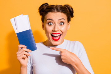 Close up photo of funky screaming charming lovely hipster surprised by getting tickets holding hand for travel journey tourism isolated over yellow background dressed in cotton light jumper