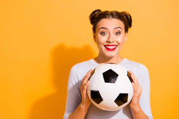 Close up photo beautiful amazing hairdo she her lady hold hands arms leather round ball captain cheerleader pray for win favorite team wearing casual white pullover isolated yellow background