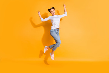 Fototapeta na wymiar Full length body size portrait of childish pretty attractive student champion celebrating victory sports competition raising fists cotton denim outfit light colored shoes isolated bright background