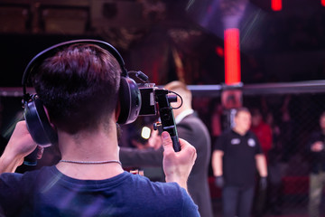 Video filming in the backstage of a sporting event. Athletes fighters in oktogon in front of the...