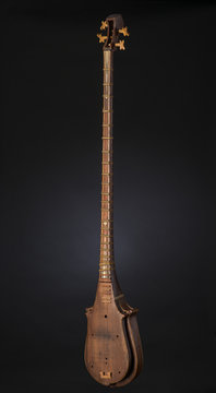 ancient Asian stringed musical instrument on black background with backlight