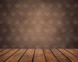 empty wooden table on a brown grunge background with pet paws