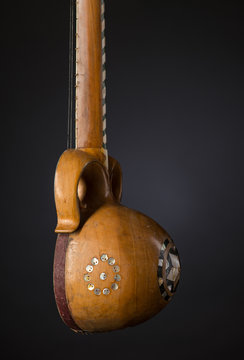 part ancient Asian stringed musical instrument on black background with backlight