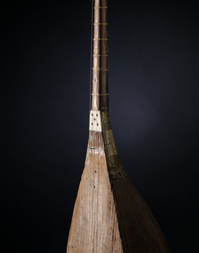 part ancient Asian stringed musical instrument on black background with backlight