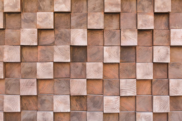 Photo of many small wooden cubes of different heights, tightly lying one after another, imitating the texture of the wall