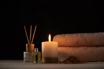 Obraz na płótnie Canvas Towels, candle and massage oil on white table