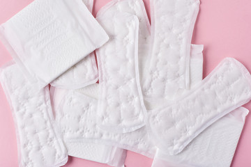 Sanitary pads on a pink background, top view