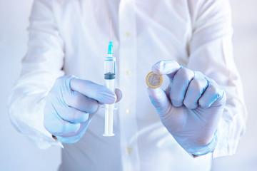 syringe and a coin, doctor showing a syringe and a coin (health care research concept)