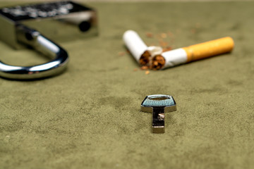 Exemption from smoking. The key on the background of a broken cigarette and an open lock