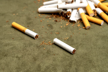 Fight against smoking. Cut cigarette on a green background