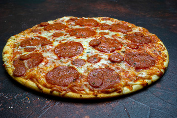 Italian pizza pepperoni on dark stone background